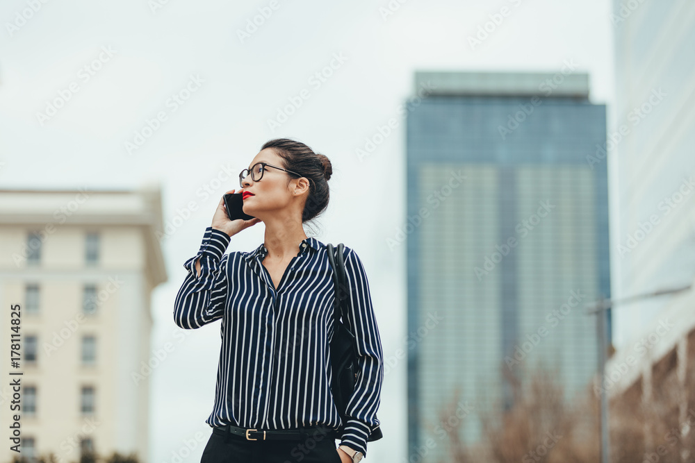 女商人带着手机在户外行走