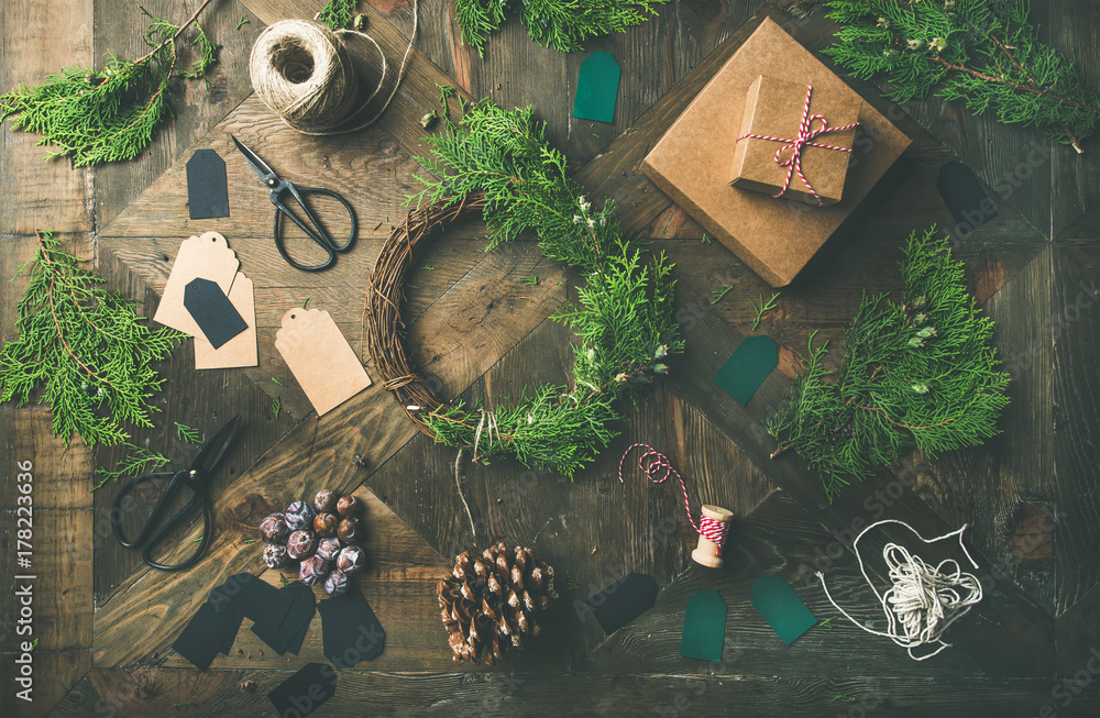 Preparing for Christmas or New Year holiday. Flat-lay of green fur tree branches, gift boxes, wreath