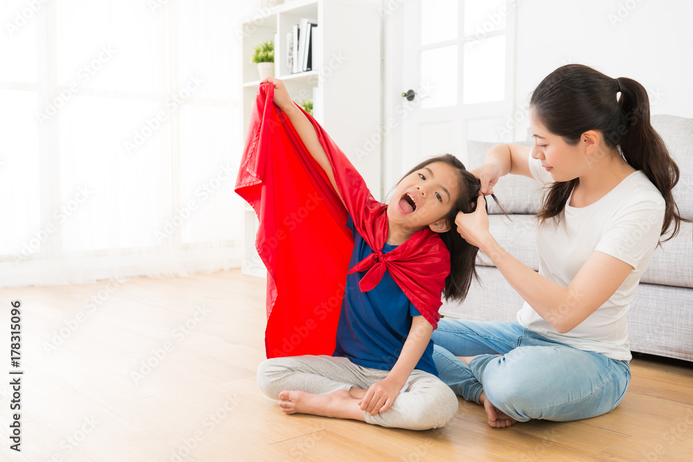 smiling mother helping little girl tired hair