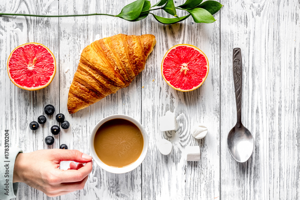 Breakfast concept with flowers on wooden background top view