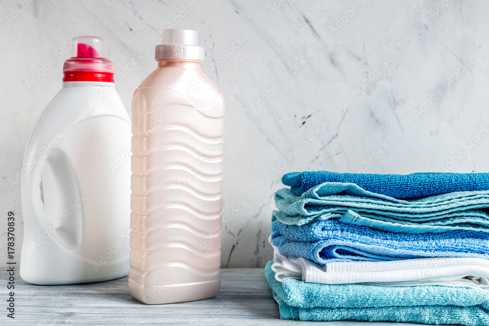 laundry set with towels and plastic bottels on gray background m