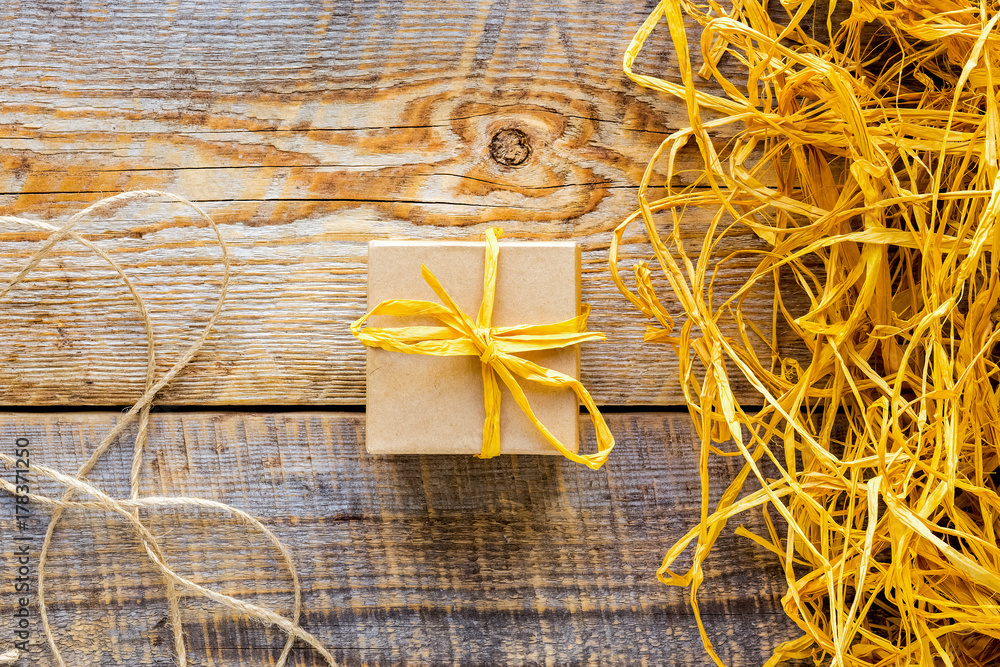 small craft gift box on wooden table with raffia