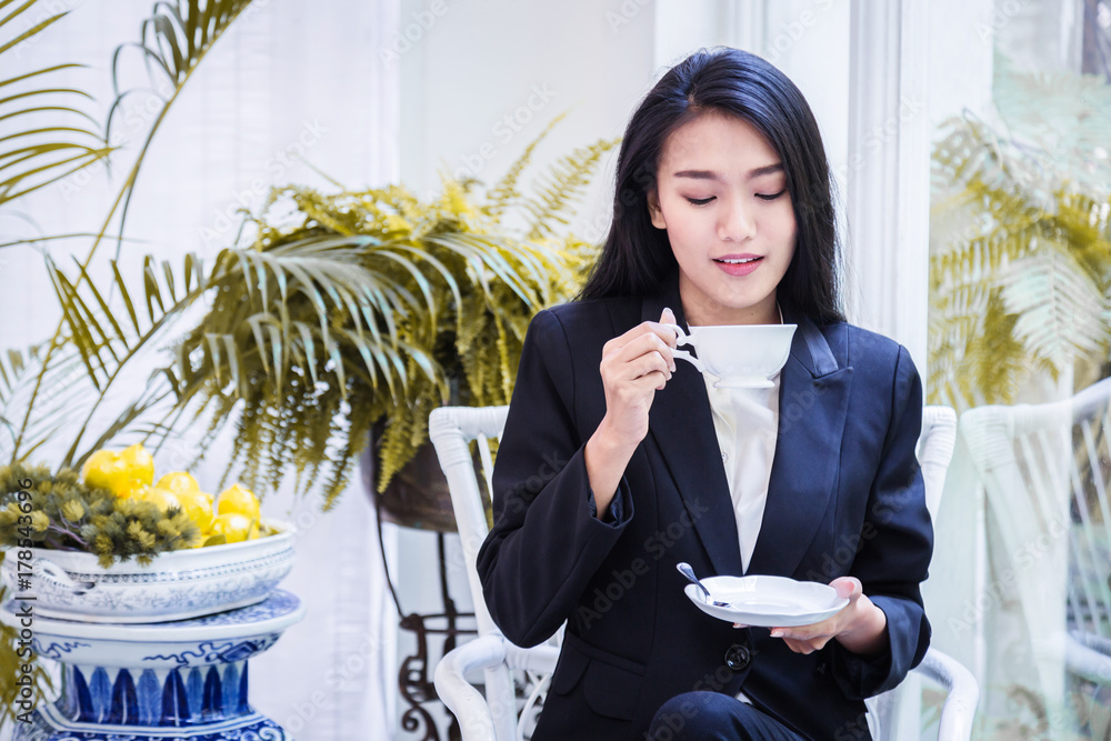 微笑的年轻女人在家里端着一杯绿茶，健康的生活方式理念，亚洲美女，亚洲b