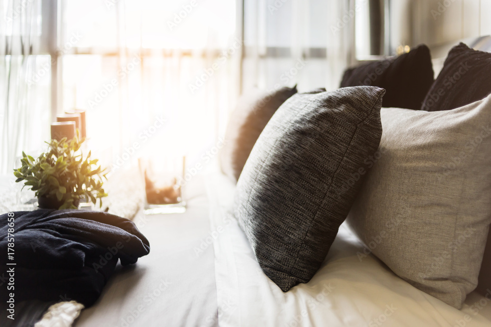 Bed maid-up with clean white pillows and bed sheets in beauty room. Close-up. Lens flair in sunlight