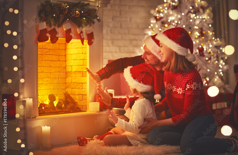 happy family sitting by fireplace on Christmas Eve.