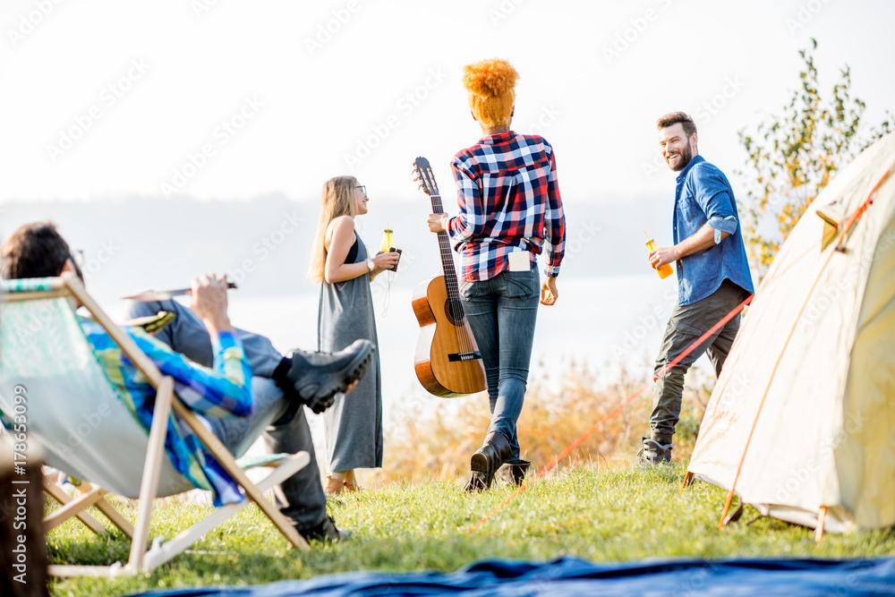 Multi ethnic group of friends dressed casually having fun during the outdoor recreation at the campi