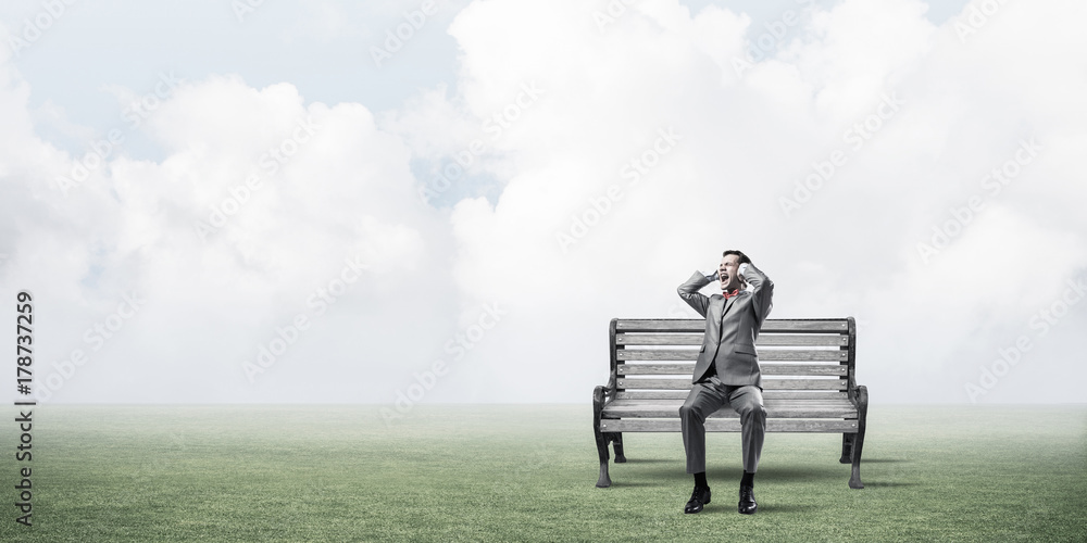 Young man in suit in park dont want to hear anything