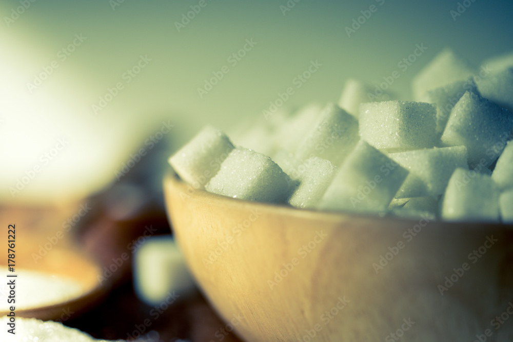  the sugar cubes  in wooden bowl on  table ,retro color tone