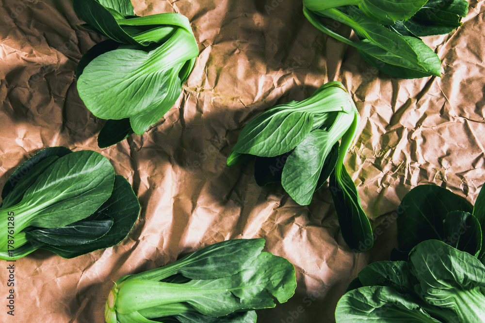 close up Fresh baby green bok choy on the crumpled paper , overhead or top view shot