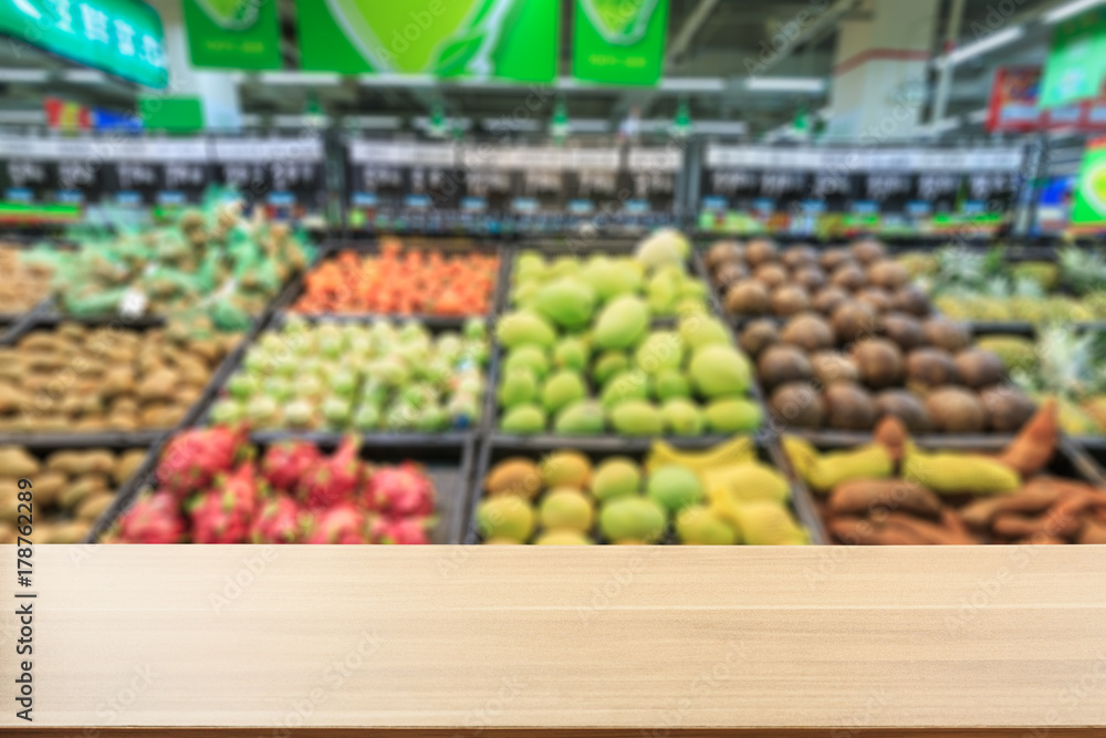 Empty wooden table and supermarket blurred fruits background