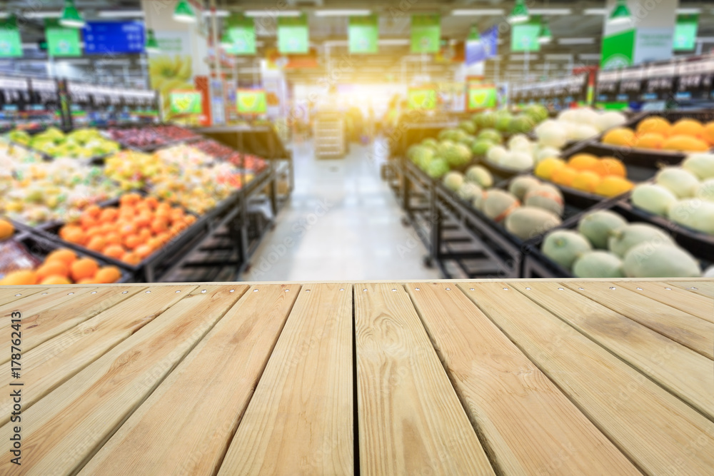 Empty wooden table and supermarket blurred fruits background