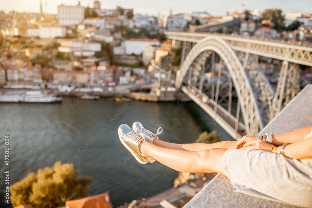 Female legs on the beautiful landscape view background during the sunset in Porto city, Portugal