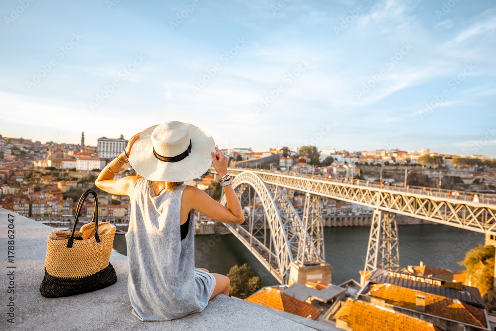 Young woman tourist enjoying beautiful landscape view on the old town with river and famous iron bri