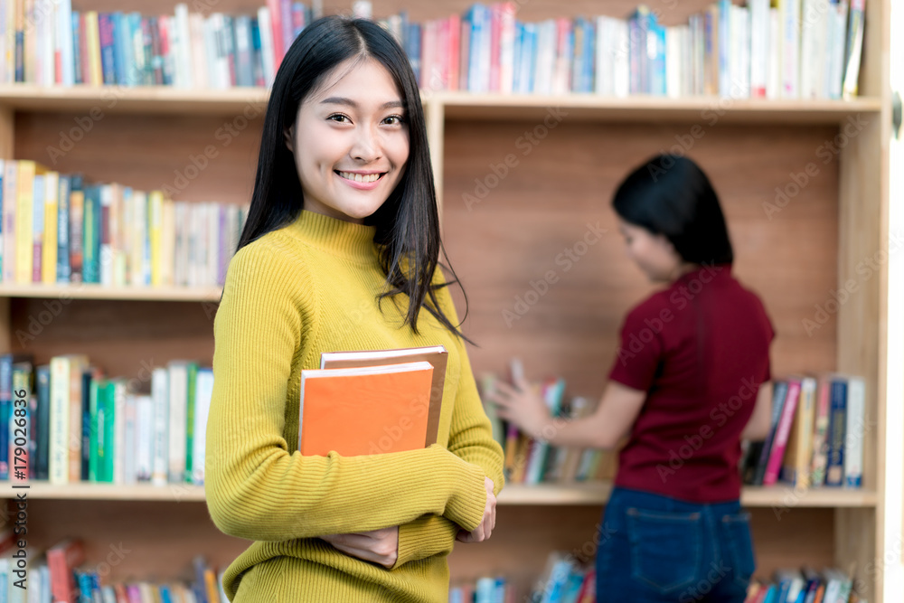 一群亚洲学生在大学图书馆一起学习。大学生。