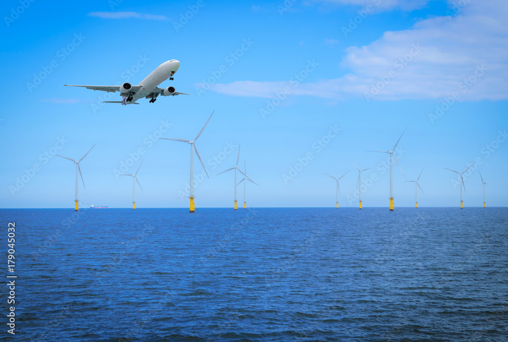 海上风力涡轮机和飞机在英格兰海岸正在建设的风电场中飞行。