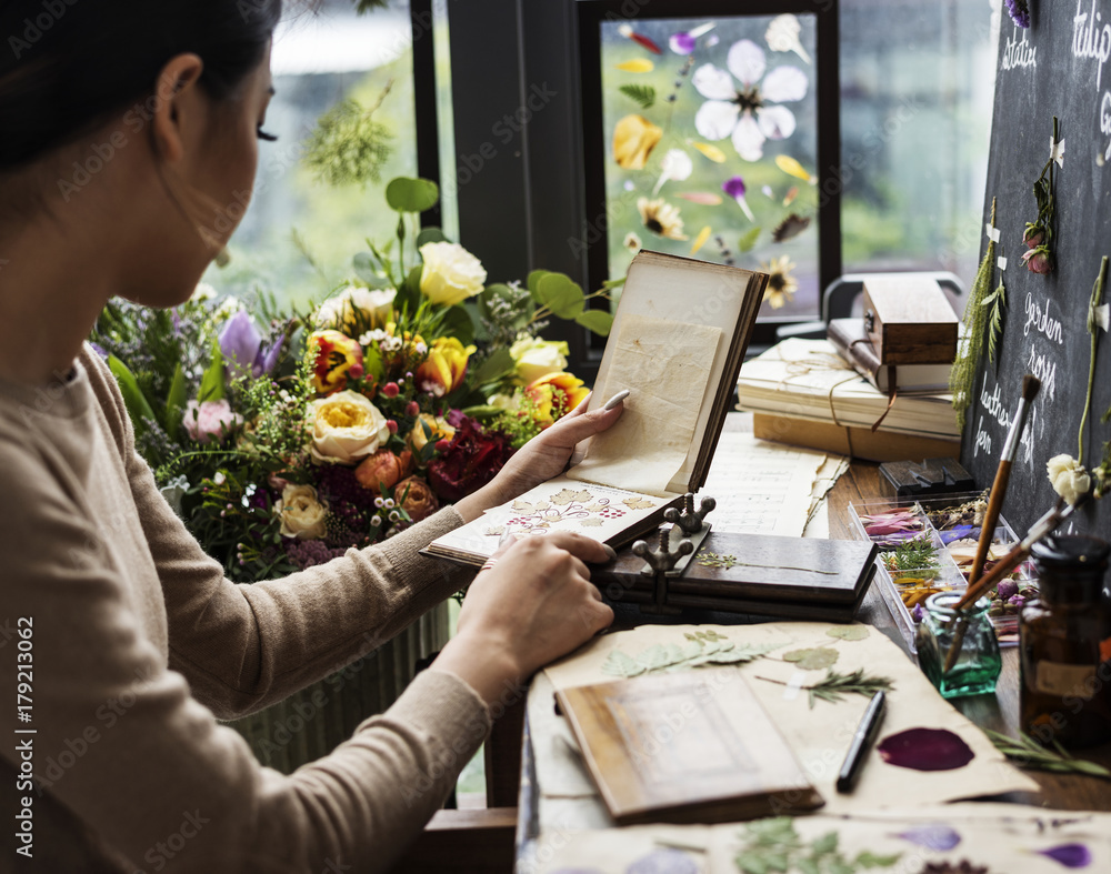 Woman looking a dried flower book