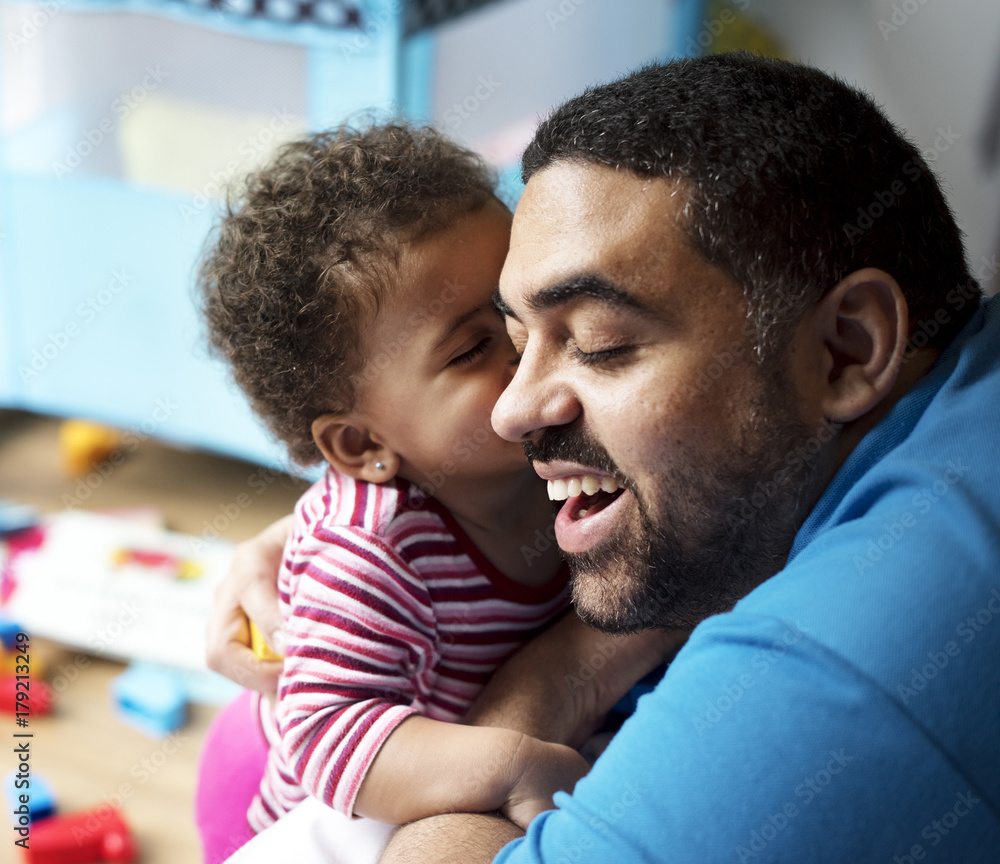 Little girl kissing dad on the cheek