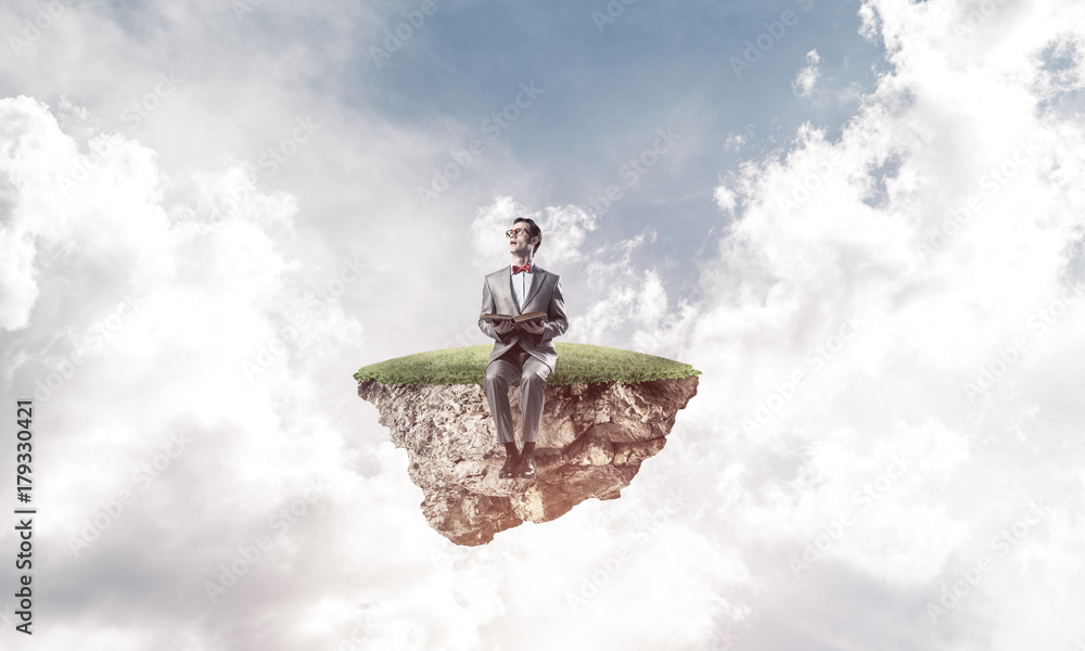 Young businessman or student floating in sky and studying the sc