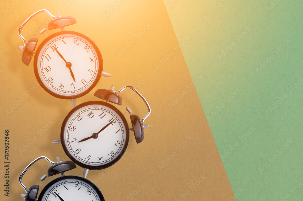 row of black alarm clock on color background wit free copyspace for your ideas text