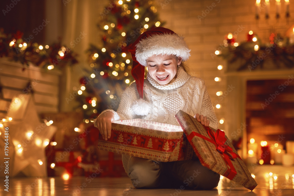 girl with gift near Christmas tree