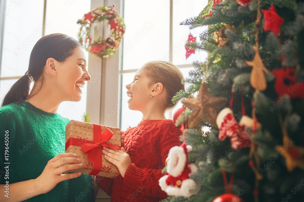 Mom and daughter decorate Christmas tree