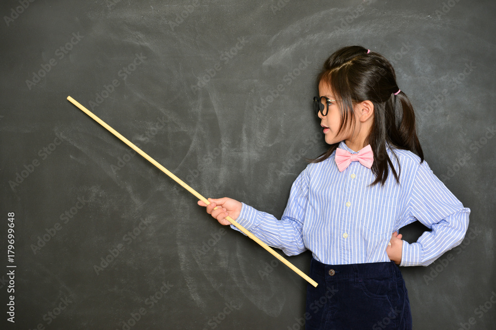 用黑色黑板教学的小女孩老师