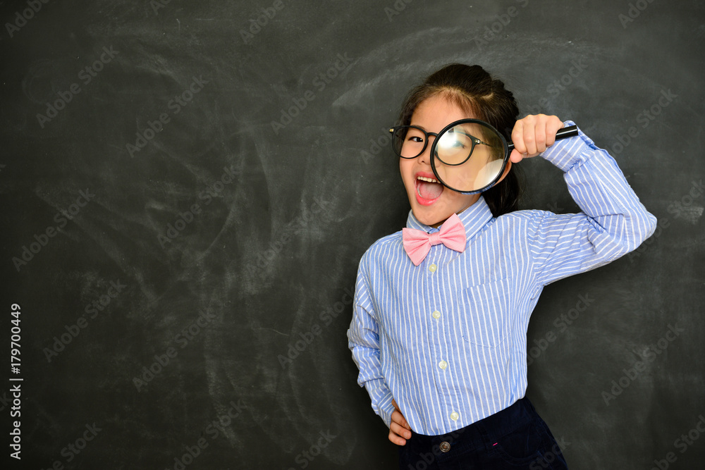 happy cheerful little teacher using magnifier