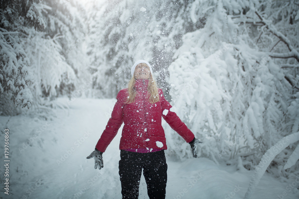 Happy blonde woman enjoys a snowy landscape.