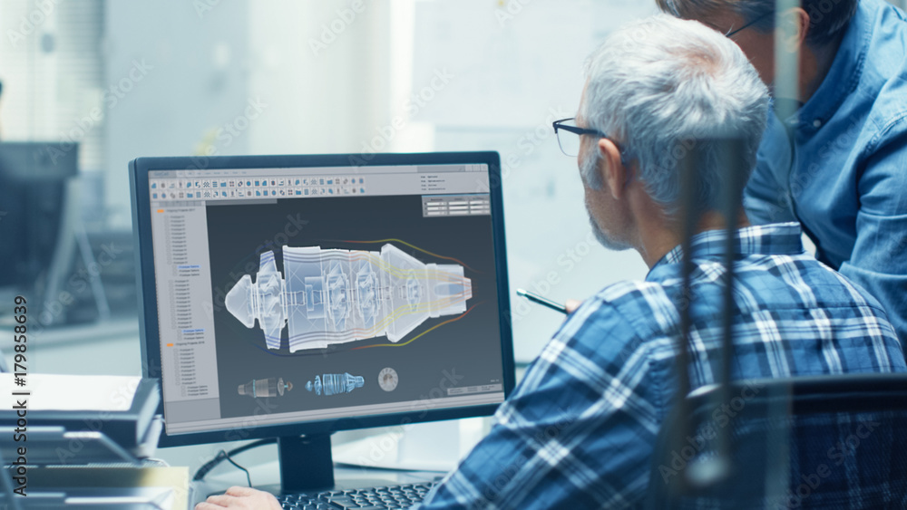 两名高级飞机工程师在个人电脑上使用涡轮蓝图。他们积极D
