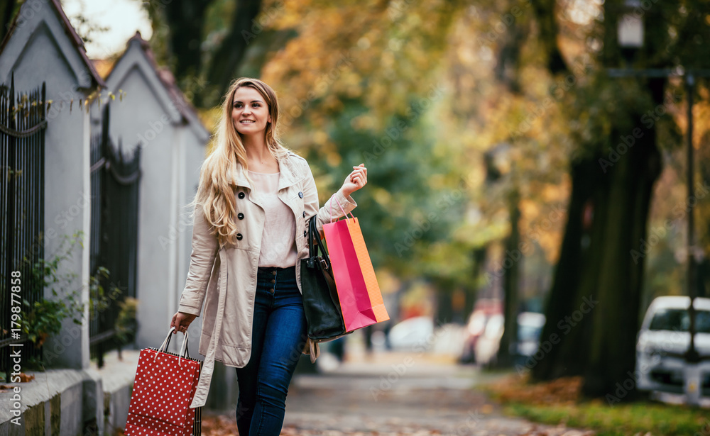 Woman with shopping bags walking in the city, casual day authentic