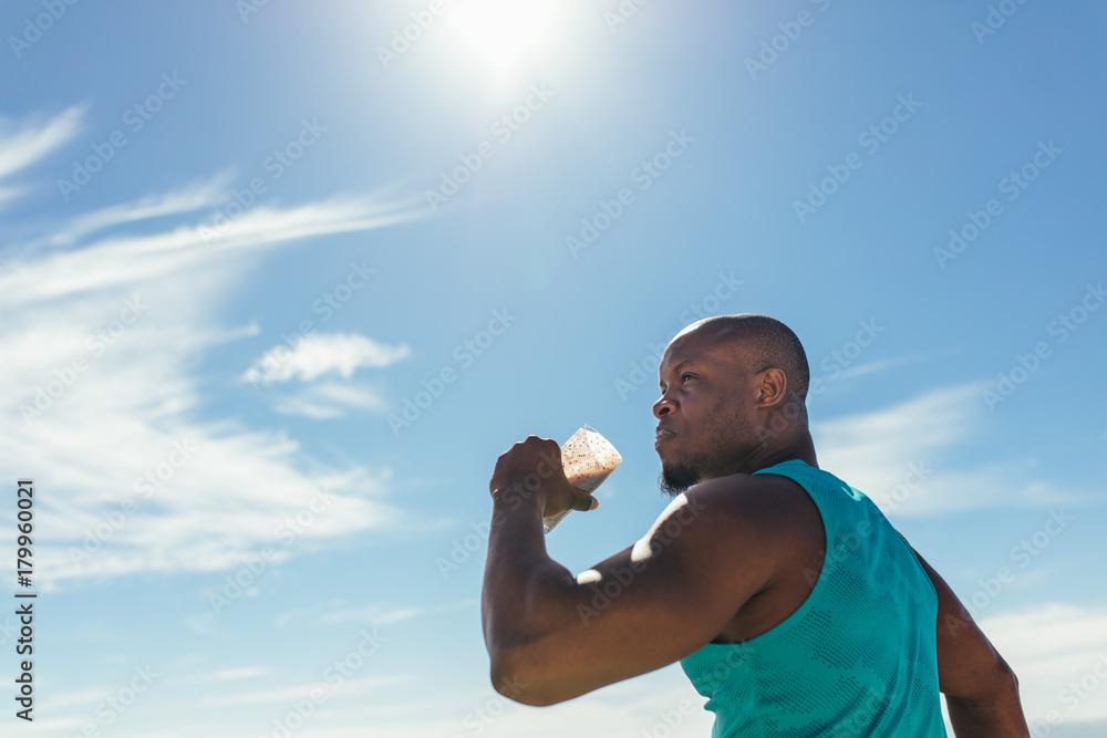 Athlete drinking health drink during workout outdoors