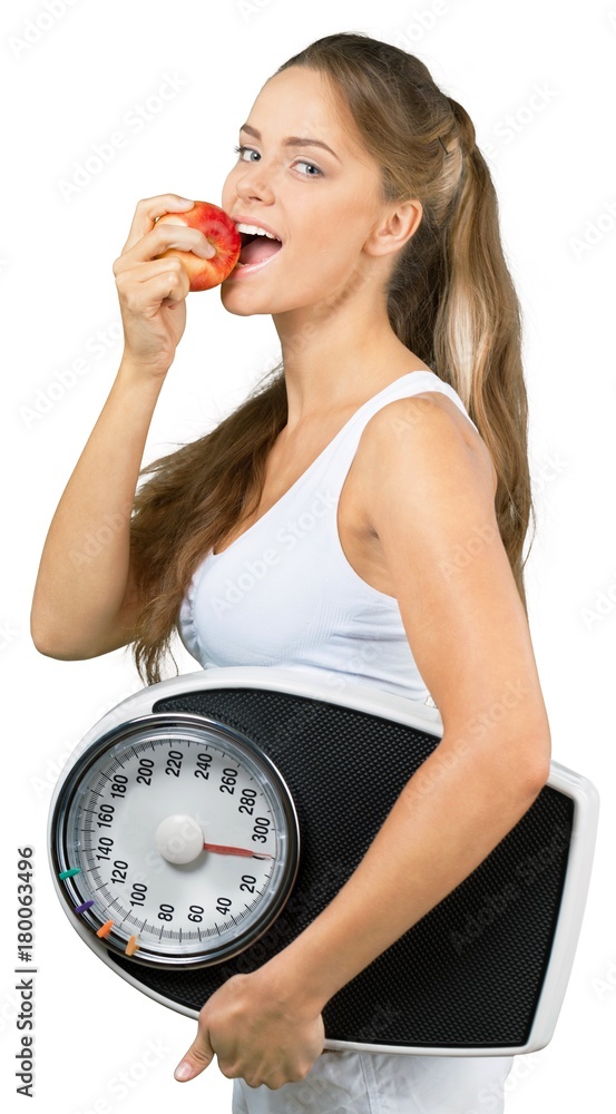 Portrait of a Fit Woman Holding a Weight Scale and Eating an