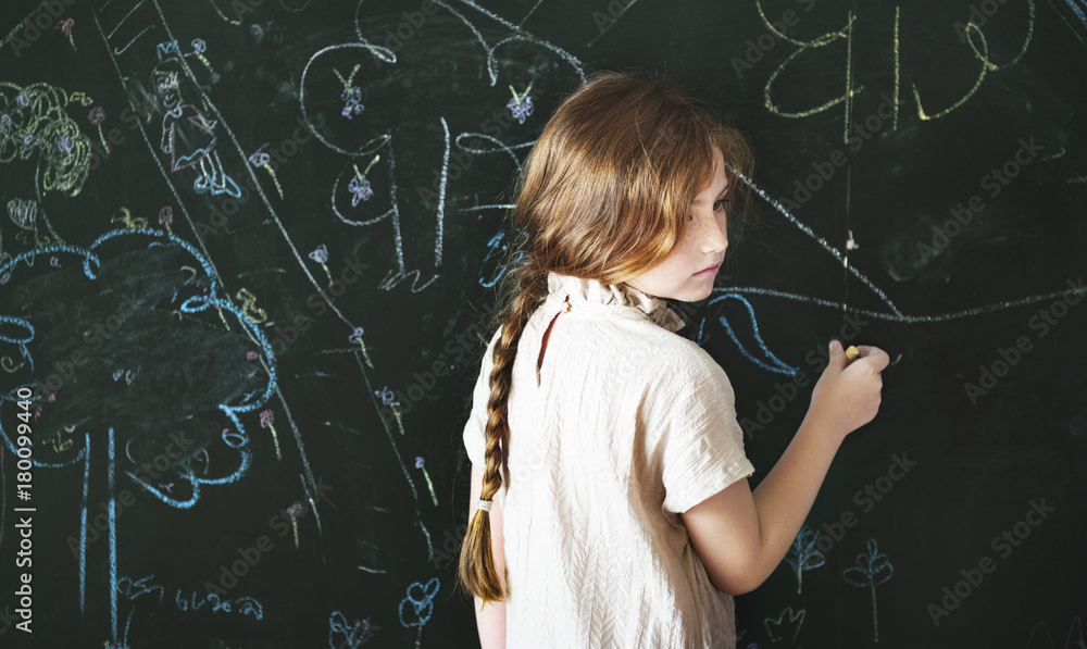 Little girl drawing on a blackboard