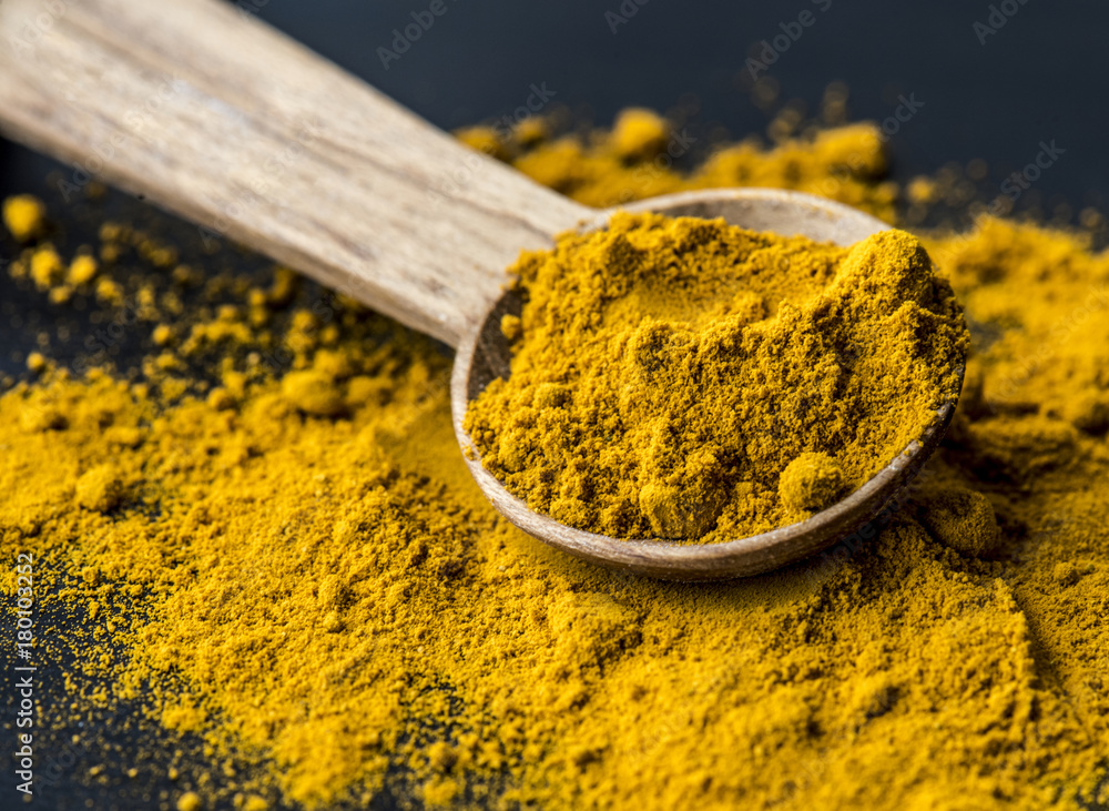 Closeup of tumeric powder spice on a spoon