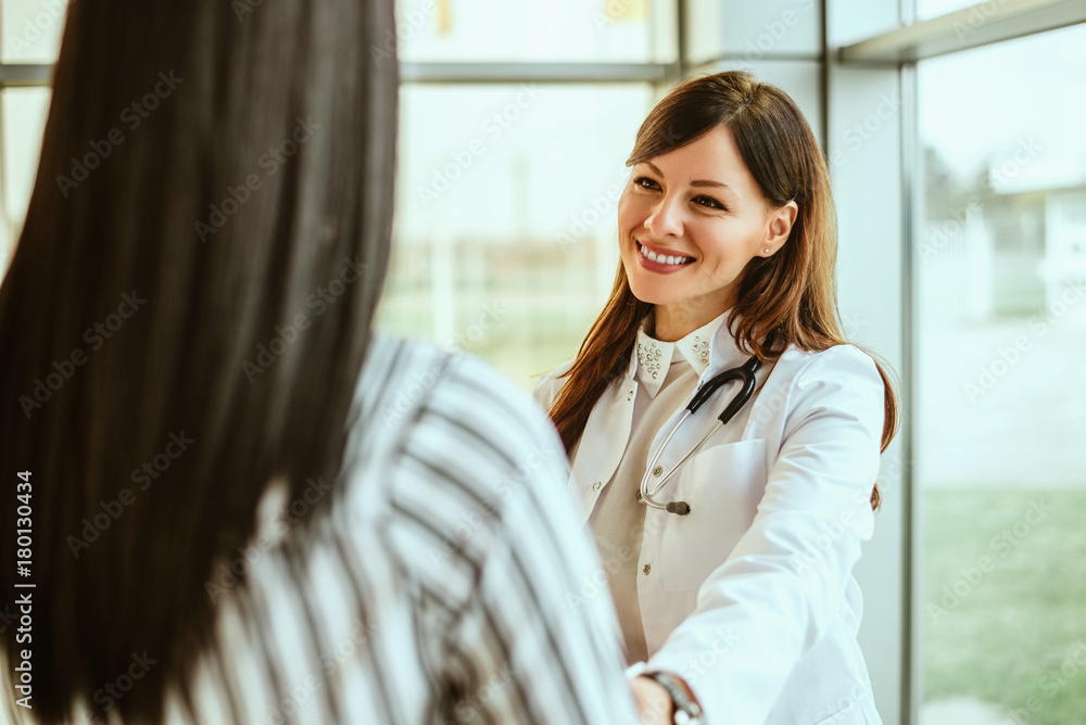 Portrait of woman doctor talking with patient.