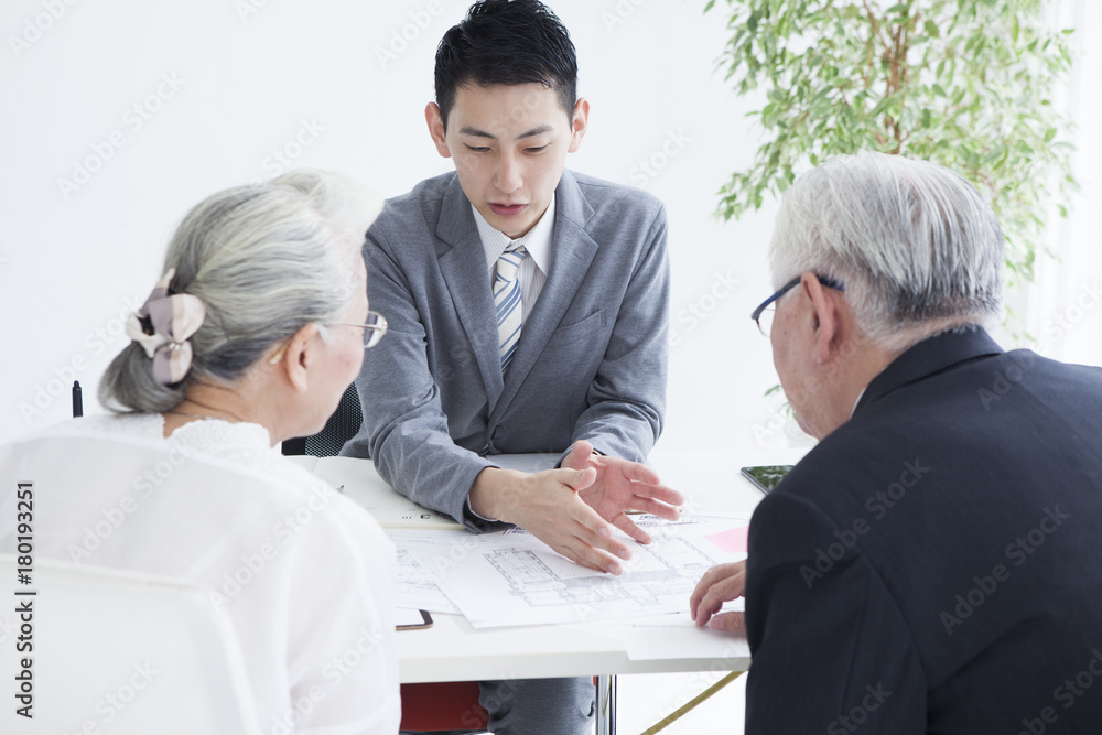 The salesman is selling the property to the elderly couple