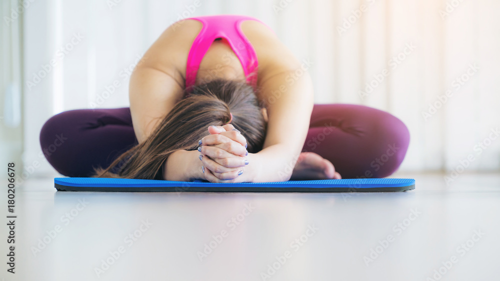 Young woman exercising stretching back yoga pose