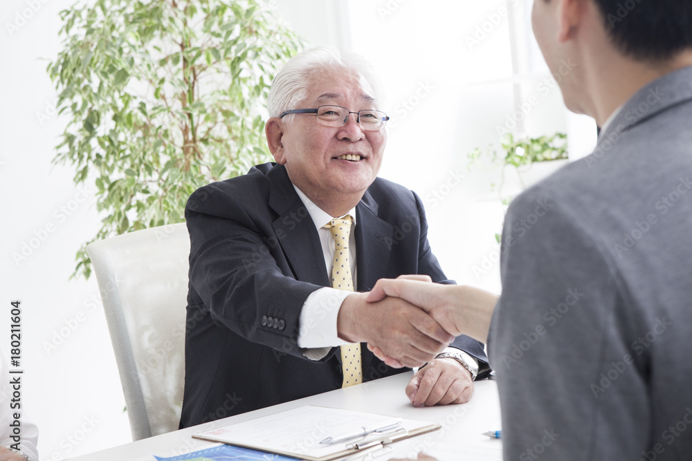 一位老人与一位销售人员握手