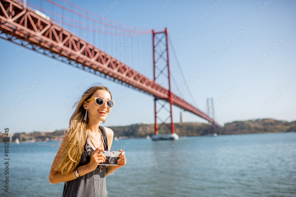 一位年轻女游客的肖像，带着相机站在著名的铁桥trav前