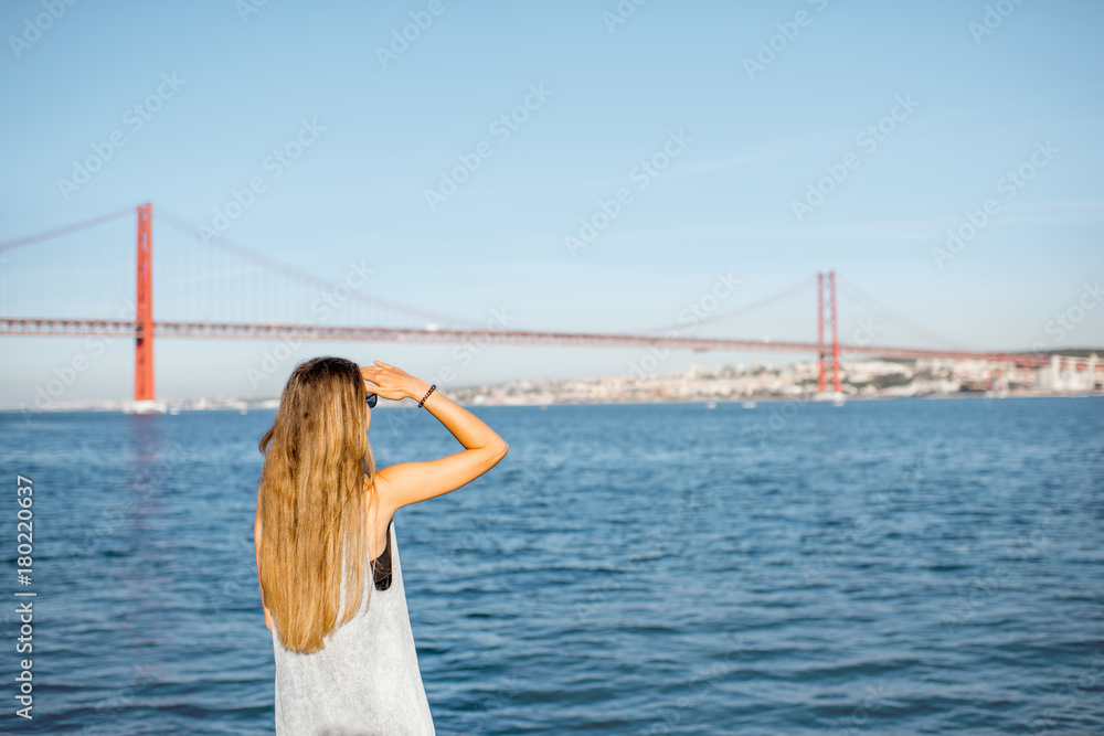 Woman enjoying beautiful landscape view on the famous iron bridge standing back near the river in Li