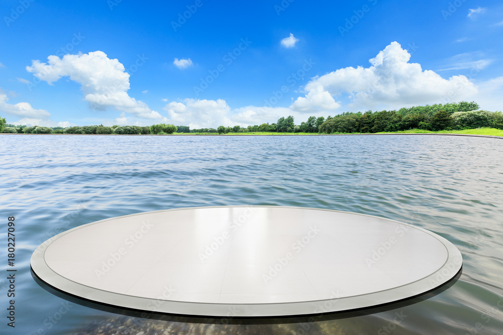 Empty round square floor and lake nature landscape in front of green forest