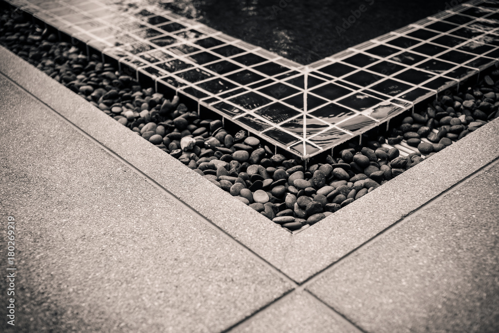 swimming pool side with pebble stone and water drain corner