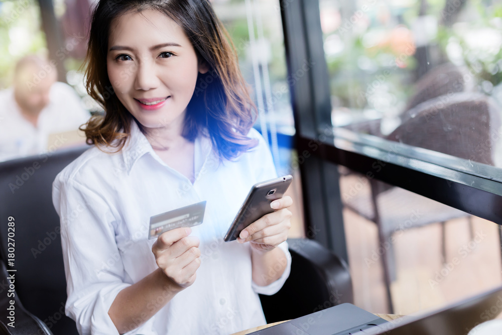 business asian girl in white shirt with credit card and smartphone onine shopping ideas concept with