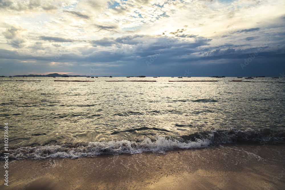 日落时的海滩、海浪和脚印