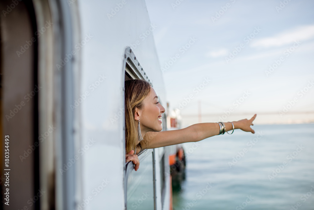 葡萄牙里斯本，一名年轻的女旅行者在水上出租车上从窗户里把脸向外拉