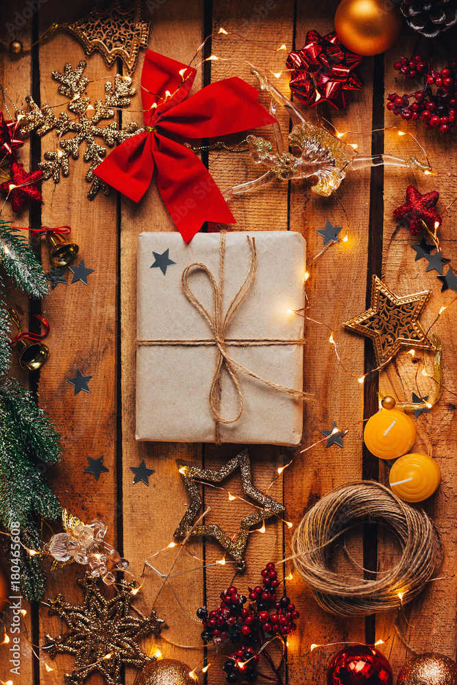 Christmas gift in a cozy atmosphere with decorations on a wooden background and a garland