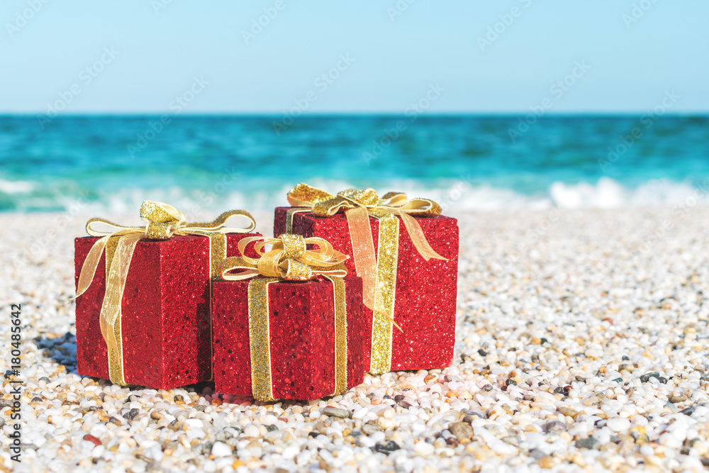 Christmas decorations in the sand on a beach on a bright and sunny day.