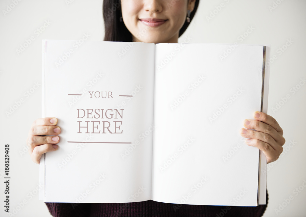 An Asian woman is holding a blank magazine