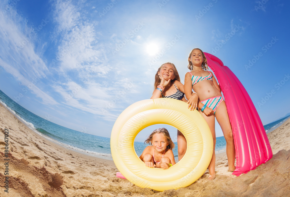 Three happy girls friends playing at sandy beach