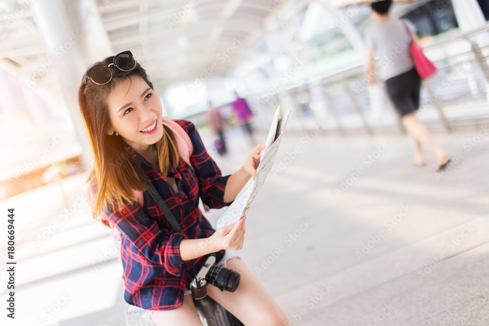 美丽幸福的年轻亚洲女孩穿着休闲服独自在火车站或机场旅行